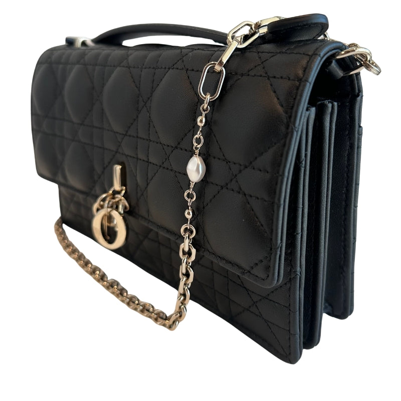 Christian Dior Top Handle
Black Lambskin
Silver-Toned Hardware
Pearls on Chain
Leather Handle
D.I.O.R Charms
Flap Closure 