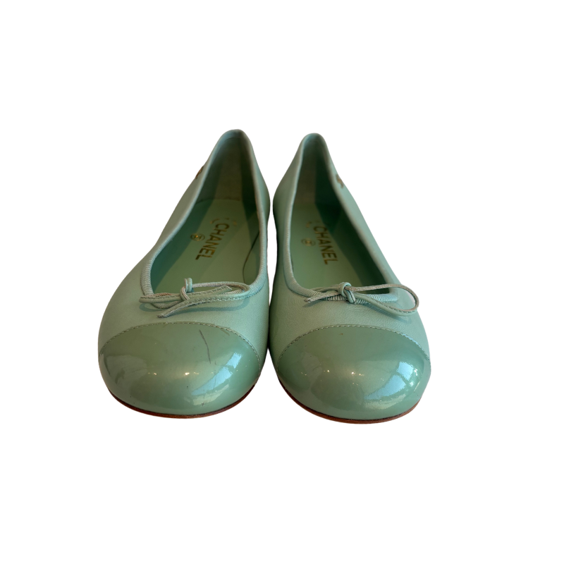 A pair of Chanel ballet flats in a glossy mint green patent leather, featuring a rounded toe and a small matching bow on the vamp, shown against a plain white background.