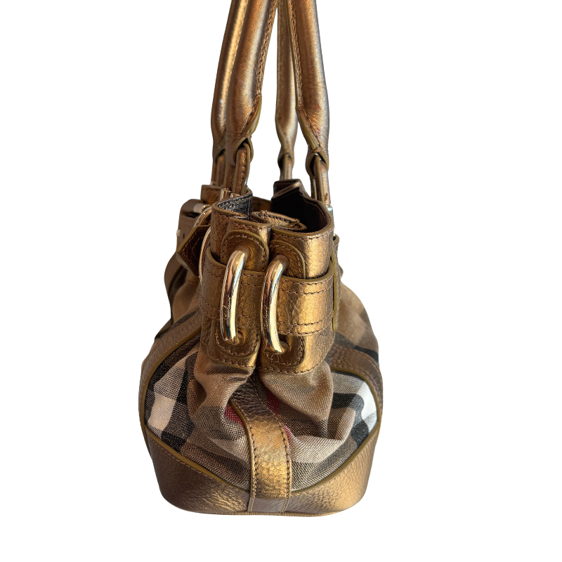 A metallic gold leather handbag with gold-tone hardware and a small section of classic check patterned fabric, shown against a plain white background.