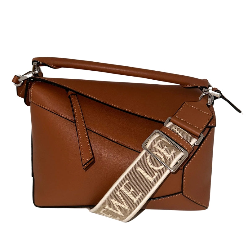 <p>Loewe Puzzle Bag</p> <p>Neutral Leather</p> <p>Silver Toned Hardware  </p> <p>Canvas Lining </p> <p>Zip Closure at Top</p> <p>Top Handle </p> <p>Adjustable Strap </p> <p>Back On Back </p>