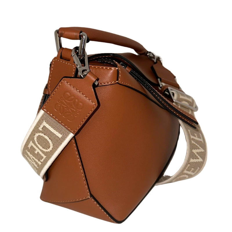 <p>Loewe Puzzle Bag</p> <p>Neutral Leather</p> <p>Silver Toned Hardware  </p> <p>Canvas Lining </p> <p>Zip Closure at Top</p> <p>Top Handle </p> <p>Adjustable Strap </p> <p>Back On Back </p>