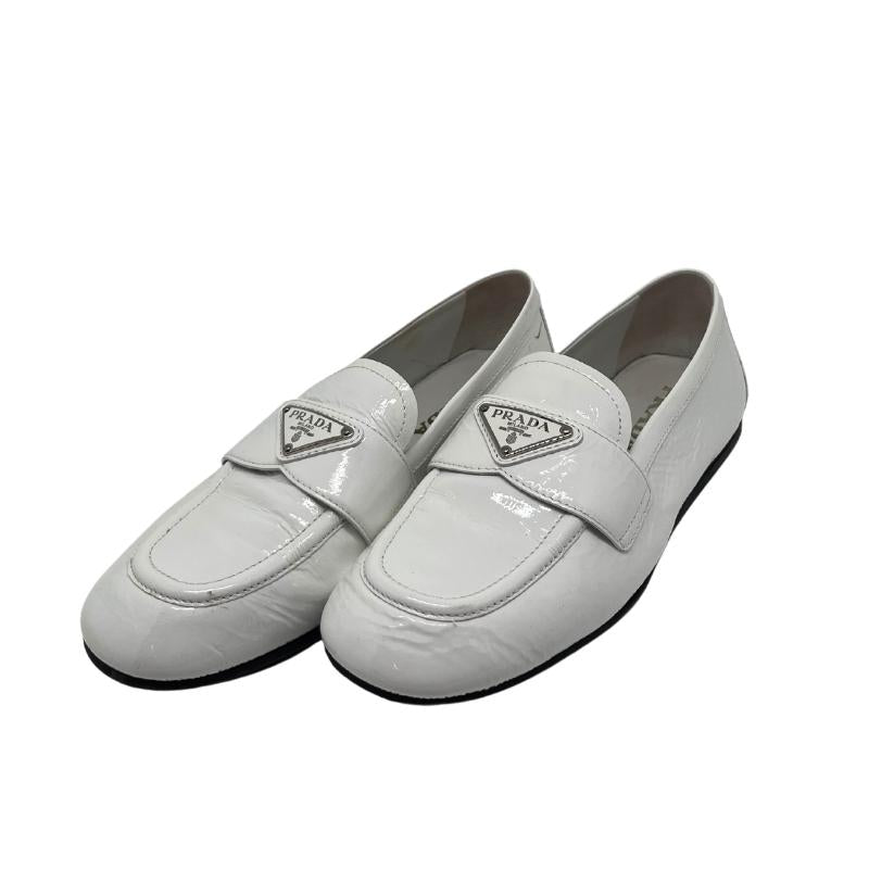 Prada white patent leather loafers, gold and white metal prada logo on front, white patent leather exterior, szie 38, rubber sole, penny loafer style, condition good with some exterior scuffs