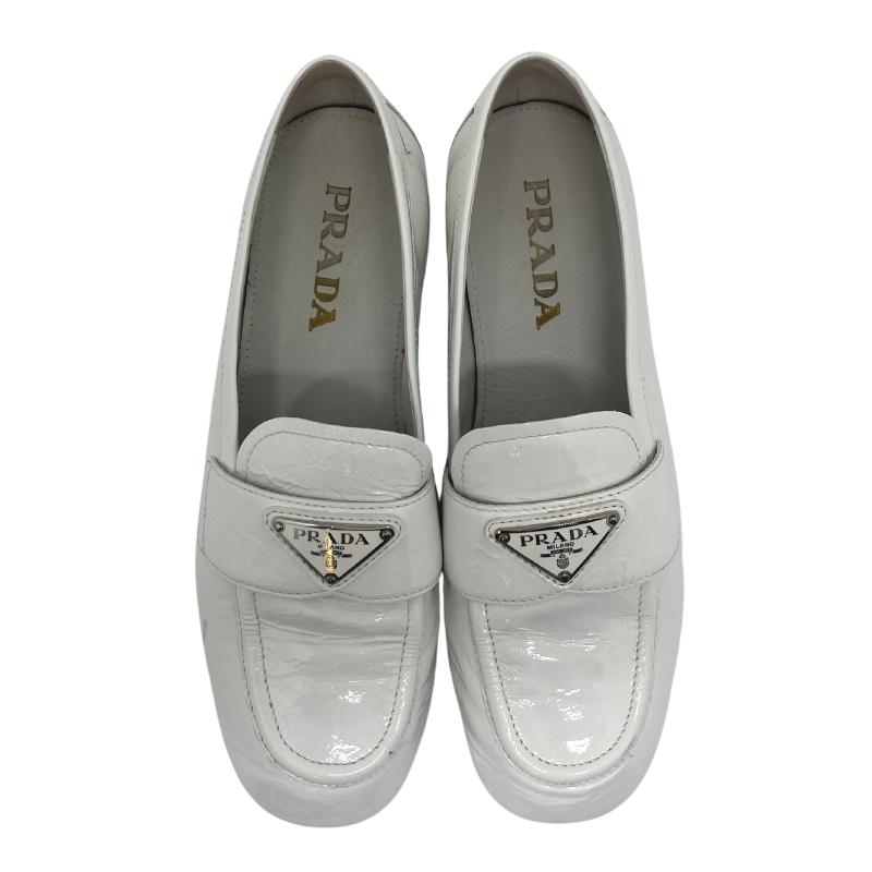 Prada white patent leather loafers, gold and white metal prada logo on front, white patent leather exterior, szie 38, rubber sole, penny loafer style, condition good with some exterior scuffs