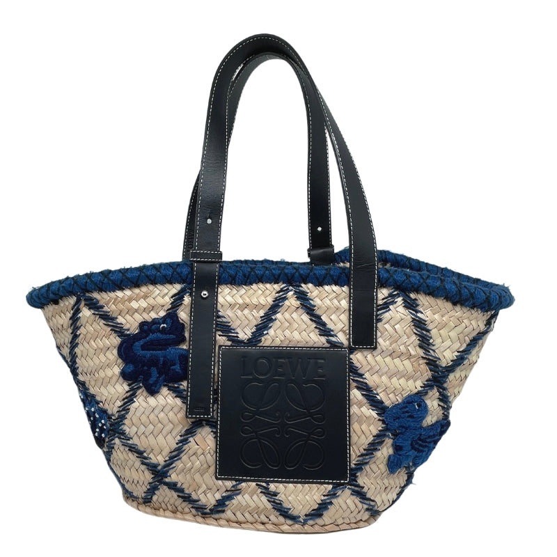 Loewe Embroidered Raffia Basket Tote   Tan Woven Raffia  Blue and Black Embroidery  Silver-Tone Hardware  Embossed Black Leather Loewe Patch   Adjustable Black Leather Straps   Unlined Interior