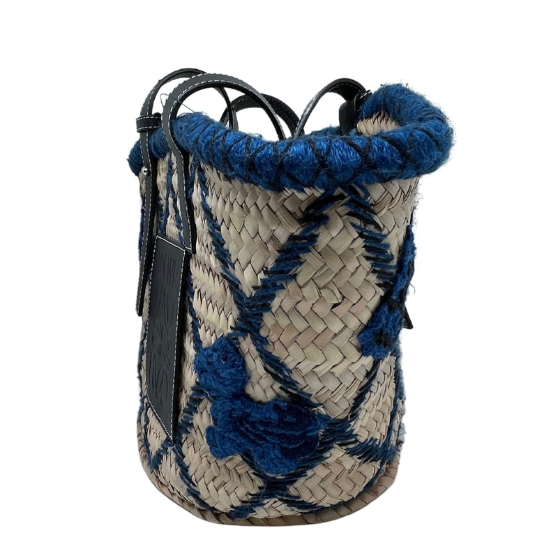 Loewe Embroidered Raffia Basket Tote   Tan Woven Raffia  Blue and Black Embroidery  Silver-Tone Hardware  Embossed Black Leather Loewe Patch   Adjustable Black Leather Straps   Unlined Interior