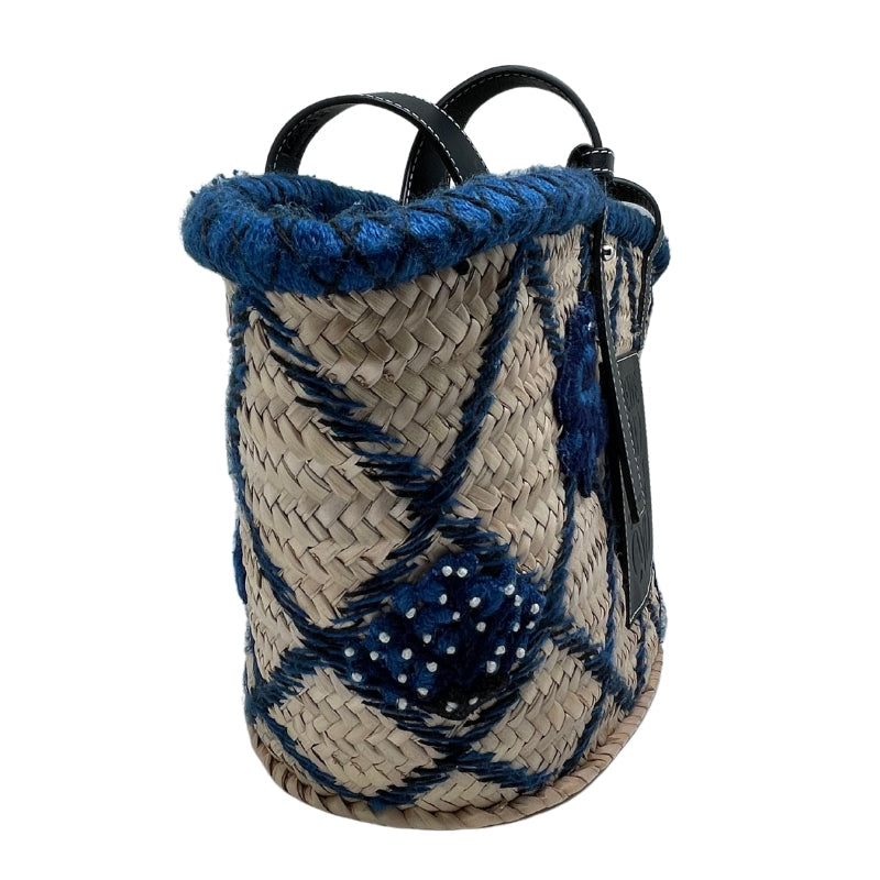 Loewe Embroidered Raffia Basket Tote   Tan Woven Raffia  Blue and Black Embroidery  Silver-Tone Hardware  Embossed Black Leather Loewe Patch   Adjustable Black Leather Straps   Unlined Interior