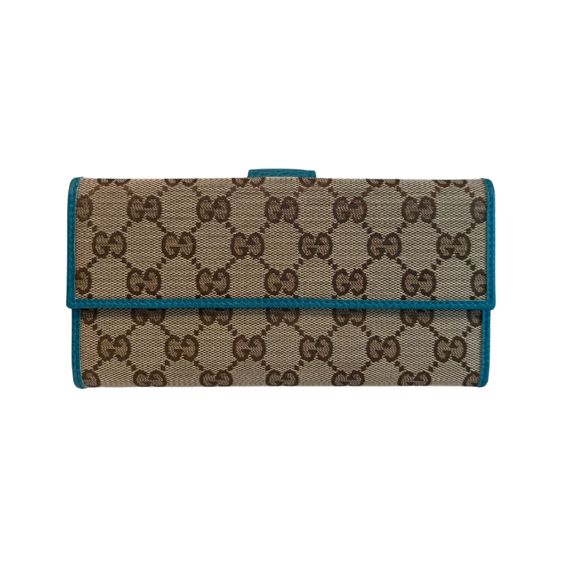 A Gucci monogram canvas clutch wallet with a teal blue leather trim and a small top tab closure, shown against a plain white background.