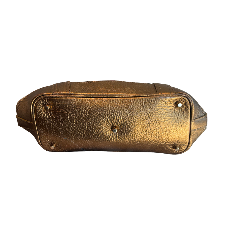 A metallic gold textured leather handbag shown from a bottom view against a plain white background.