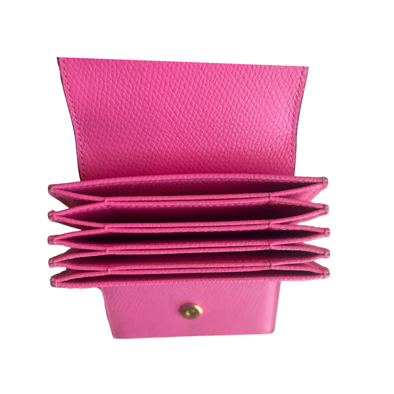 A bright pink textured leather multi-card holder wallet shown open, displaying multiple card slots and a snap button closure, set against a plain white background.