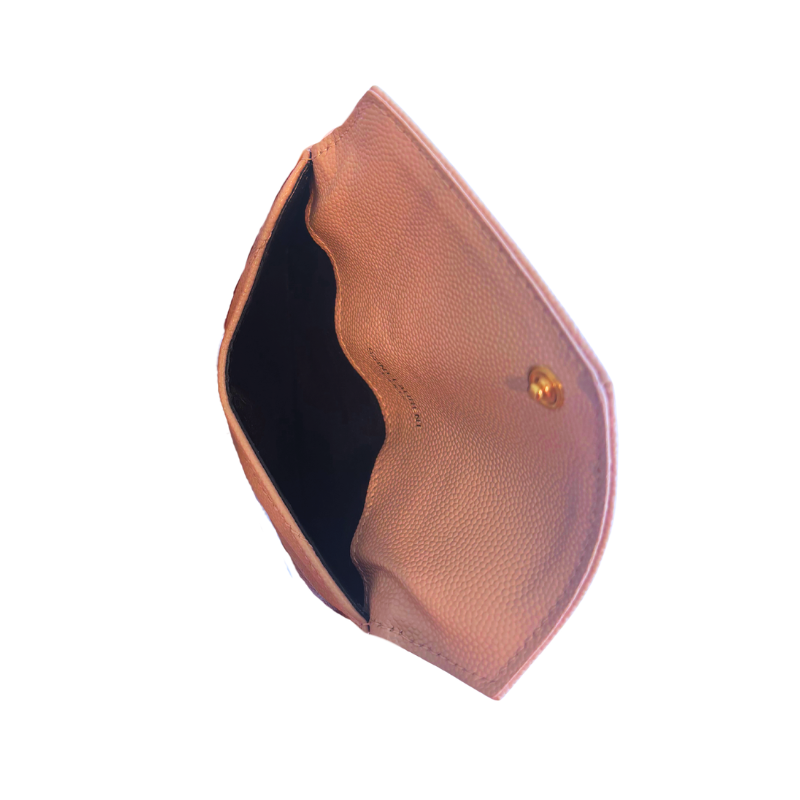 A close-up of a blush pink pebbled leather pouch or card holder, shown open to reveal a black interior lining and a small gold snap button on the side, set against a plain white background.