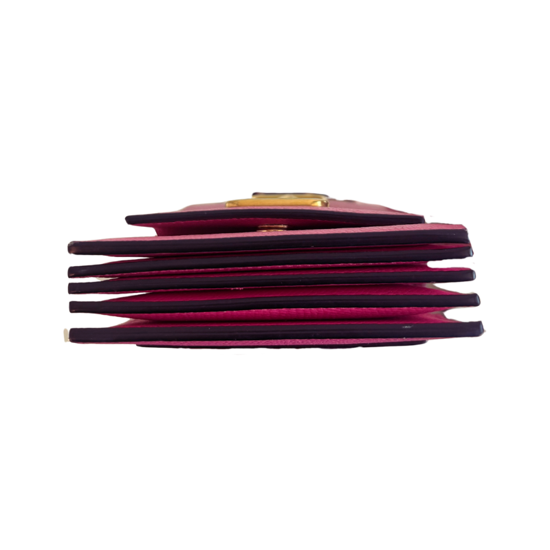 Bottom view of pink leather wallet with a gold-tone metal clasp, shown against a plain white background.
