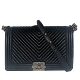 Chanel Black Boy Bag&nbsp;  Black Lambskin&nbsp;  Interlocking&nbsp;CC Logo  Chevron Pattern  Silver-Toned Accents&nbsp;  Chain Link Strap Accent  Push Lock Closure at Front&nbsp;  Grosgrain Lining Interior&nbsp;  Interior Pocket&nbsp;  Condition: Great, minor scratches on inside flap&nbsp;