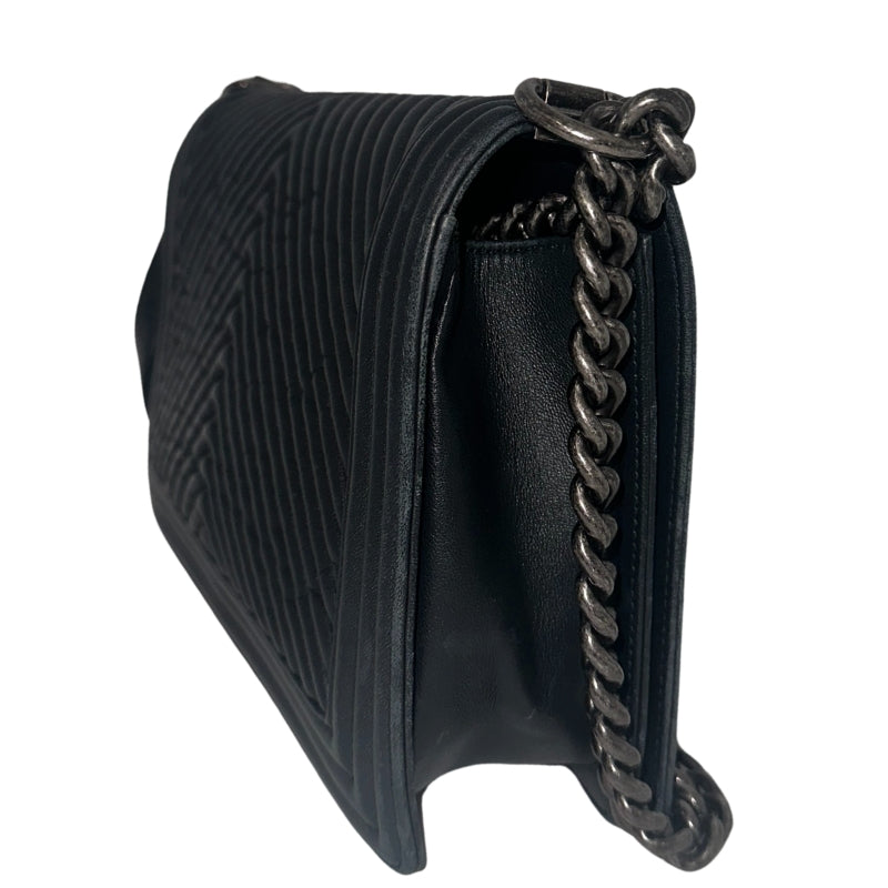 Chanel Black Boy Bag&nbsp;  Black Lambskin&nbsp;  Interlocking&nbsp;CC Logo  Chevron Pattern  Silver-Toned Accents&nbsp;  Chain Link Strap Accent  Push Lock Closure at Front&nbsp;  Grosgrain Lining Interior&nbsp;  Interior Pocket&nbsp;  Condition: Great, minor scratches on inside flap&nbsp;