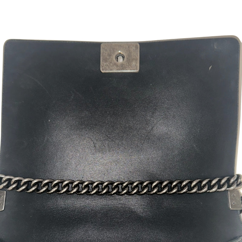 Chanel Black Boy Bag&nbsp;  Black Lambskin&nbsp;  Interlocking&nbsp;CC Logo  Chevron Pattern  Silver-Toned Accents&nbsp;  Chain Link Strap Accent  Push Lock Closure at Front&nbsp;  Grosgrain Lining Interior&nbsp;  Interior Pocket&nbsp;  Condition: Great, minor scratches on inside flap&nbsp;