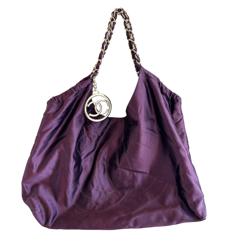 Chanel Coco Cabas XL&nbsp;

Purple Satin&nbsp;

Gold-Toned Hardware

CC Logo Charm&nbsp;

Leather Shoulder Handles

Fabric Lined Interior&nbsp;