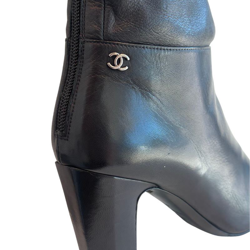 Close Up of Chanel Interlocking CC Metal Cap Toe Knee-High Leather Boots on a White Background