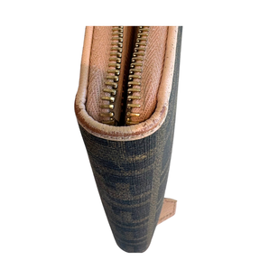 Close-up of a Fendi wallet, showing the textured brown and black canvas pattern, a tan leather trim, and a gold-toned double zipper.