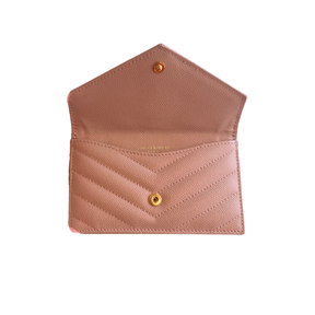 A blush pink pebbled leather card holder with a chevron quilted front pocket and gold-tone snap buttons, shown open against a plain white background.