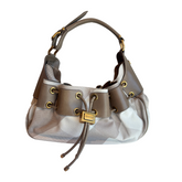 A brown and beige patterned shoulder bag with gold-tone hardware, featuring a drawstring closure and a top handle, shown against a plain white background.