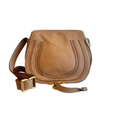 A tan pebbled leather shoulder bag with a curved flap, double vertical stitched details, and a matching leather strap with gold-tone hardware, shown on a plain white background.