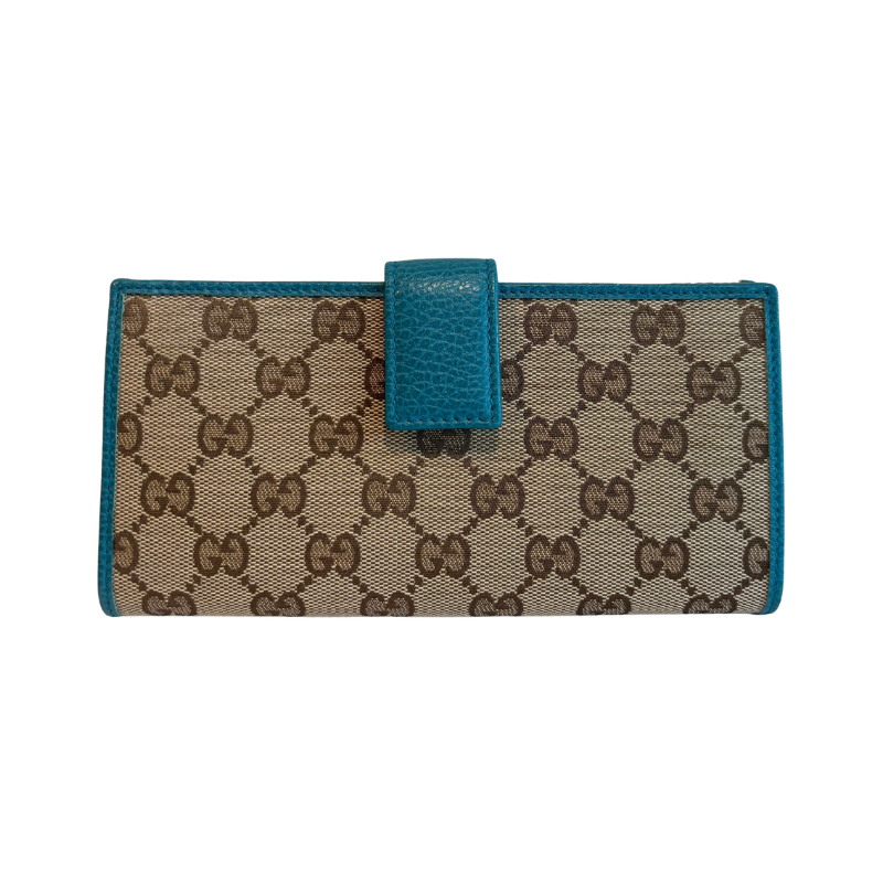 A Gucci monogram canvas wallet with teal leather trim and a matching teal leather tab closure, shown against a plain white background.