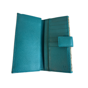 A teal blue pebbled leather wallet shown open, displaying its interior card slots, a side pocket with a snap tab closure, and a patterned paper insert on the right side.
