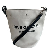 Saint Laurent Rive Gauche Bucket Bag&nbsp;  Off-White Linen&nbsp;  Black Leather Detachable Strap&nbsp;  Black Pouch Included&nbsp;  Snap Closure at Top&nbsp;