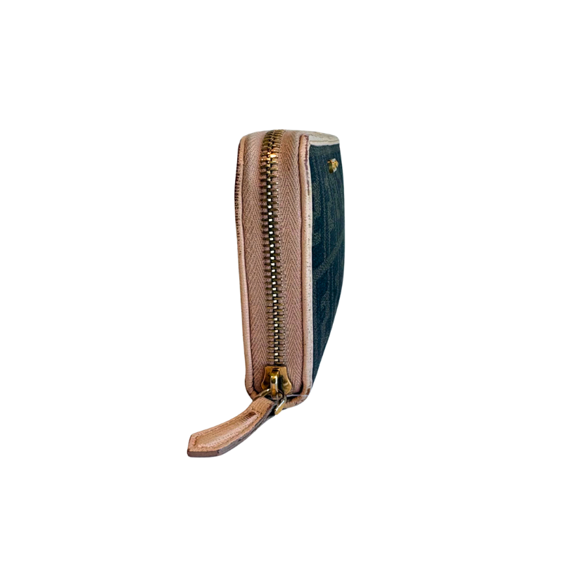 A slim zip-around wallet shown upright against a plain white background. The wallet features a textured light brown leather front, a dark teal-blue fabric side panel, and a gold-tone metal zipper with a pull tab.