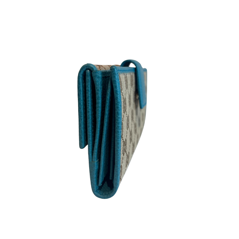 A folded leather wallet shown from the side, featuring a textured teal blue leather trim and a beige and gray patterned interior.