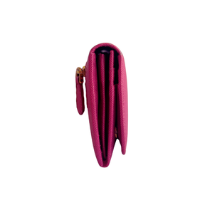 A close-up side view of a textured pink leather wallet with a gold zipper pull, set against a plain white background.