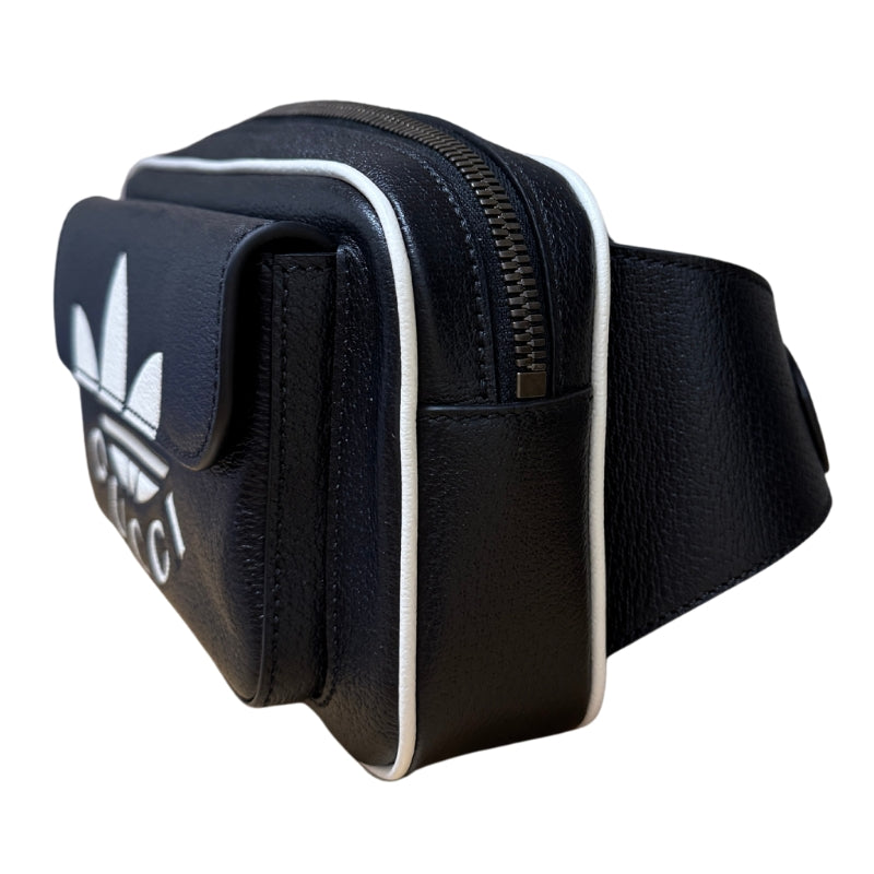 Gucci Trefoli Waist Bag

ADIDAS x Gucci

ADIDAS Motif&nbsp;

Textured Dollar&nbsp;

Black and White Calfskin

Gold-Toned Hardware&nbsp;

Travel Bag&nbsp;

Adjustable Strap&nbsp;

Zipper at Top&nbsp;