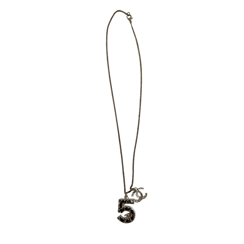 Chanel 5 Necklace&nbsp;

Silver

5 Charm

CC Charm

Black and Diamon Detailing&nbsp;

Clasp&nbsp;

Length: 14"&nbsp;