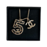 Chanel 5 Necklace&nbsp;

Silver

5 Charm

CC Charm

Black and Diamon Detailing&nbsp;

Clasp&nbsp;

Length: 14"&nbsp;