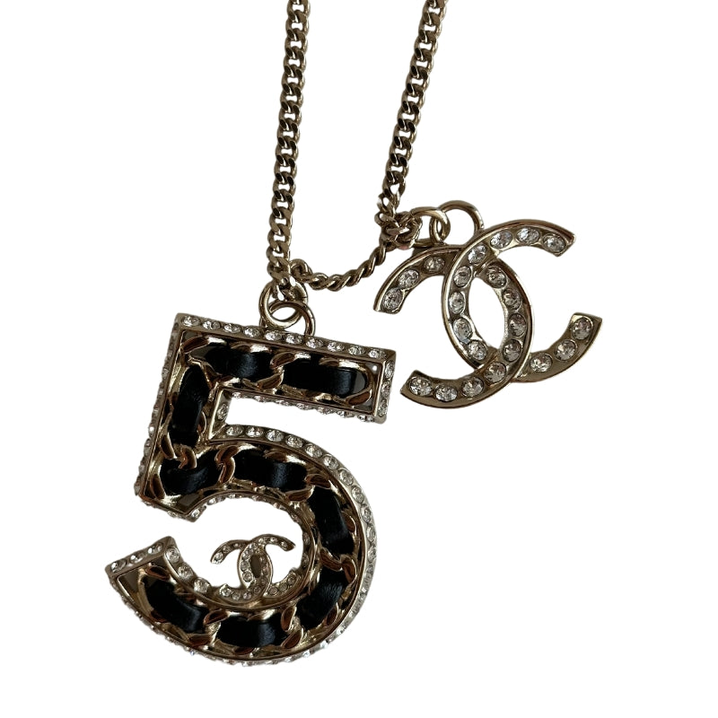 Chanel 5 Necklace&nbsp;

Silver

5 Charm

CC Charm

Black and Diamon Detailing&nbsp;

Clasp&nbsp;

Length: 14"&nbsp;