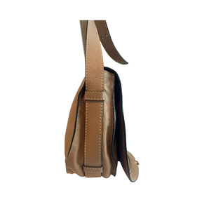 A side profile view of a tan pebbled leather shoulder bag with a matching leather strap, shown against a plain white background.