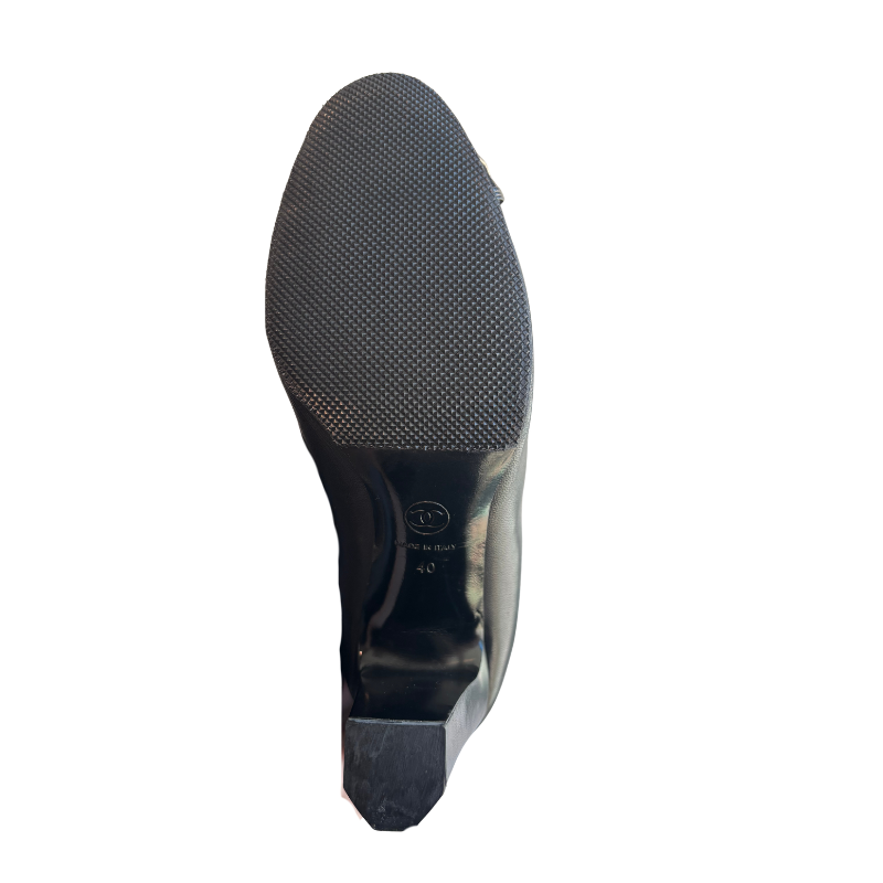 Sole of Chanel Interlocking CC Metal Cap Toe Knee-High Leather Boots on a White Background 