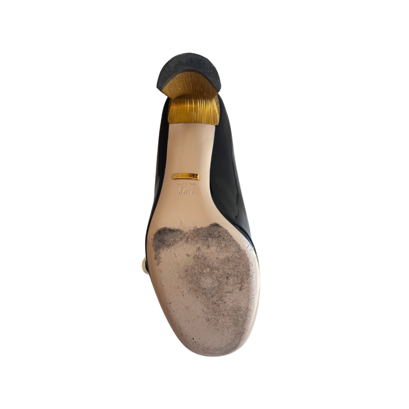 Sole of Gucci Patent Leather Crystal Pearl Embellished Mary Jane Heels on a White Background. 