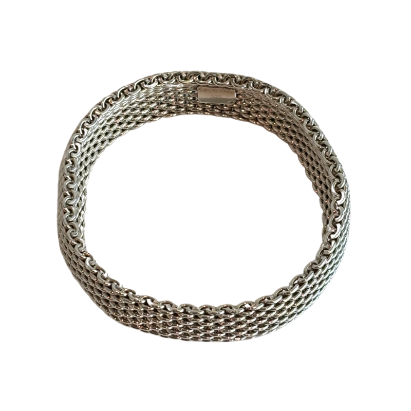 A silver-toned metal mesh bracelet with a woven chain pattern, shown on a plain white background.