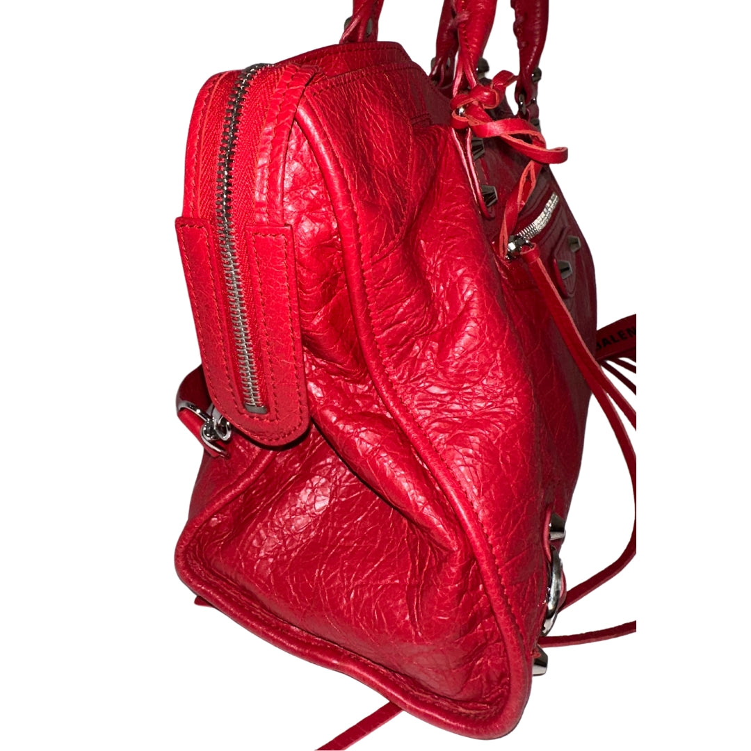 Balenciaga Motorcross City Bag&nbsp;

Red Exterior&nbsp;

Twiggy Model Bag

Zip Closure&nbsp;

Multiple Interior Pockets&nbsp;

Balenciaga Font Across Strap&nbsp;

Top Handles &amp; Adjustable Strap&nbsp;