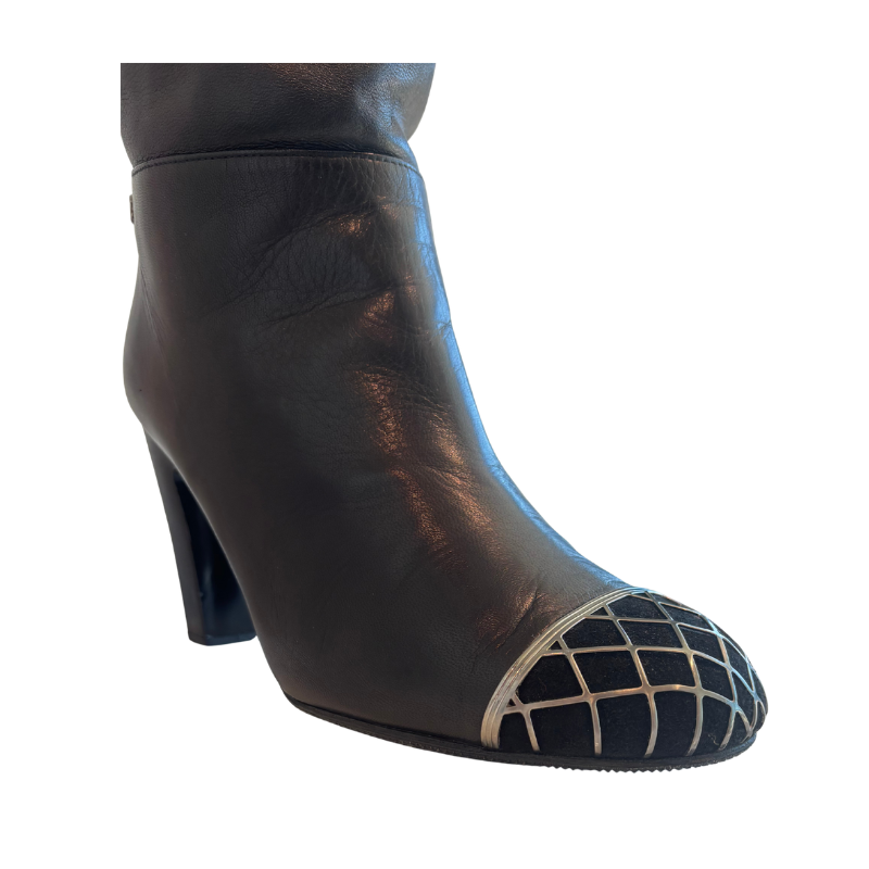 View of Toe on Chanel Interlocking CC Metal Cap Toe Knee-High Leather Boots on a White Bckground