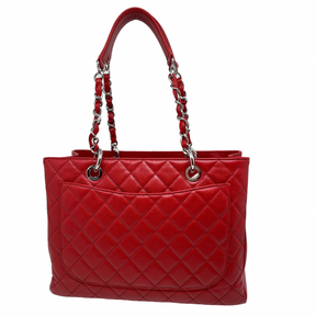 Chanel Grand Shopping Tote in quilted red caviar leather with chain link shoulder strap, interlocking CC logo, single exterior pocket, three interior pockets, and open top. Like new condition