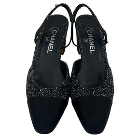 Front View: Black, Interlocking CC Logo, Rounded Toe with Glitter Accents, Strap and Closure at Sides. 
