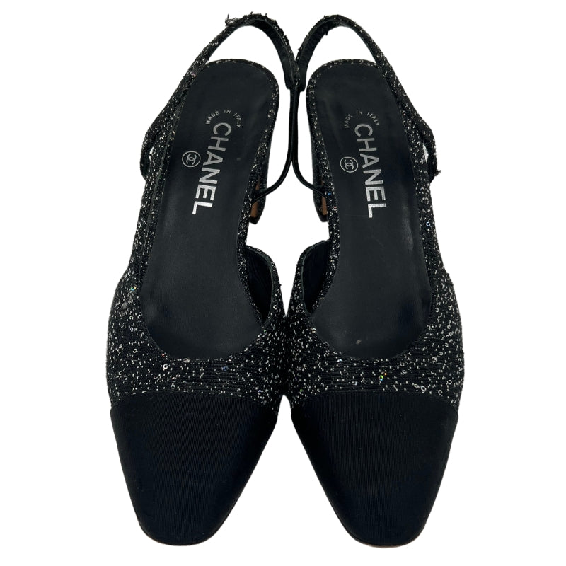 Front View: Black, Interlocking CC Logo, Rounded Toe with Glitter Accents, Strap and Closure at Sides. 