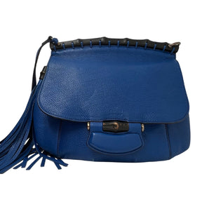 Front View: Blue Leather, Flap Bag, Two Tassels, Bamboo Top and Accents, Adjustable Leather Shoulder Strap. 