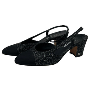 Side View: Black, Interlocking CC Logo, Rounded Toe with Glitter Accents, Strap and Closure at Sides, Block Heels. 