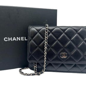 Chanel lambskin classic wallet on chain, black quilted lambskin leather exterior, silver hardware, single chain shoulder strap, silver cc logo at front snap closure, grosgrain lining, four interior pockets with card slots, condition excellent, front view