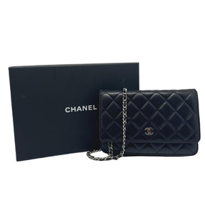 Chanel lambskin classic wallet on chain, black quilted lambskin leather exterior, silver hardware, single chain shoulder strap, silver cc logo at front snap closure, grosgrain lining, four interior pockets with card slots, condition excellent, front view