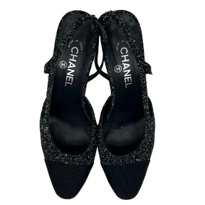 Overview: Black, Interlocking CC Logo, Rounded Toe with Glitter Accents, Strap and Closure at Sides.