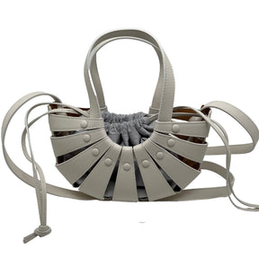 Front View 1: Cutout Leather Mini Tote Bag, Top Handle, Long Shoulder Strap, Interior Pouch with Drawstring Closure. 