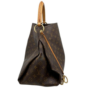 Louis Vuitton monogram artsy MM, brown LV logo coated canvas exterior, rolled handles, brass hardware, open top, alcantara lining, seven interior pockets, condition good, some distressing on sides, side view